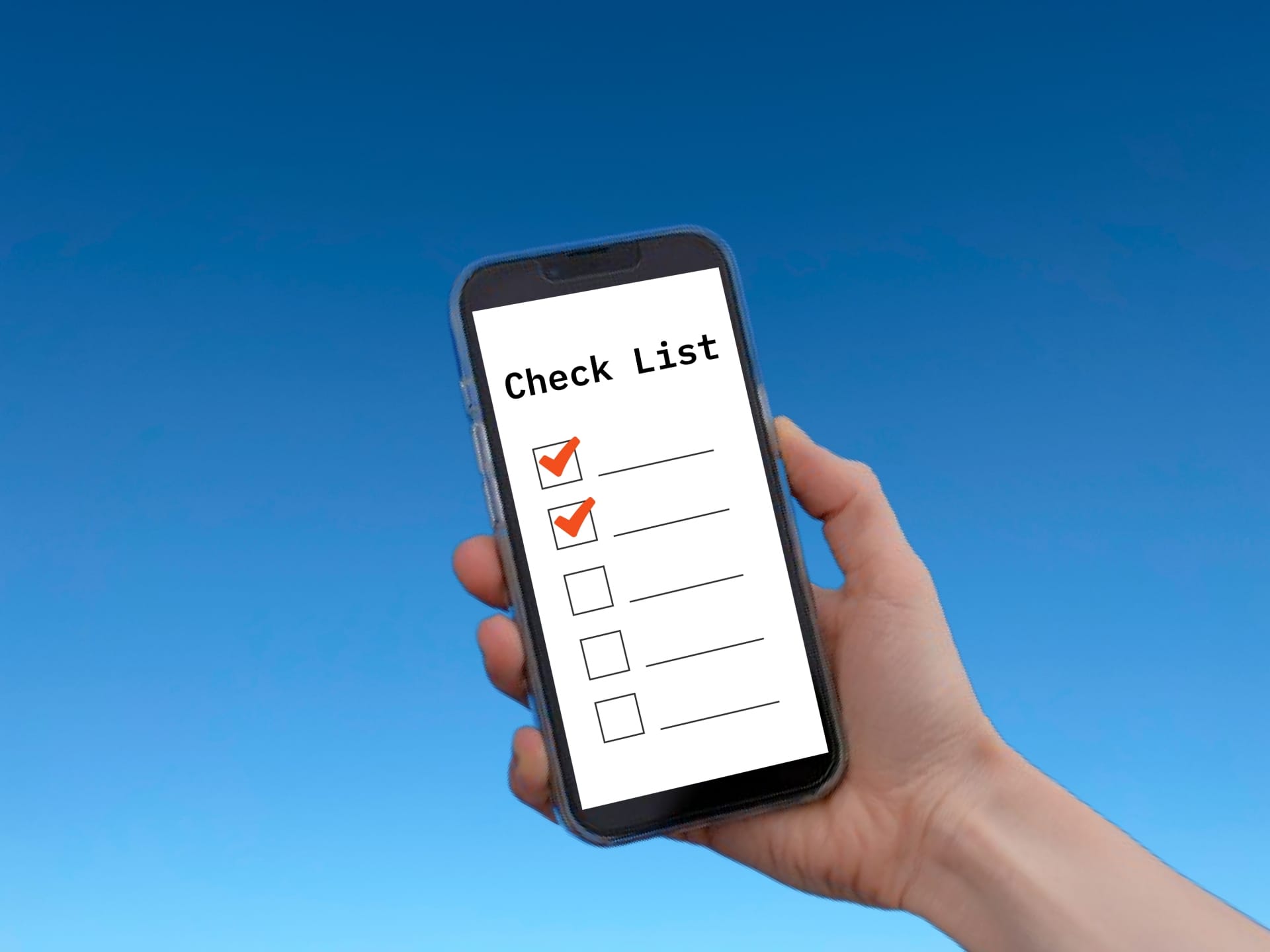 Hand holding a smartphone showing a checklist app with red checkmarks on a white list against a blue sky background.